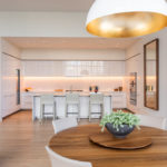 Hall Arts Residences white kitchen and wooden dining table.