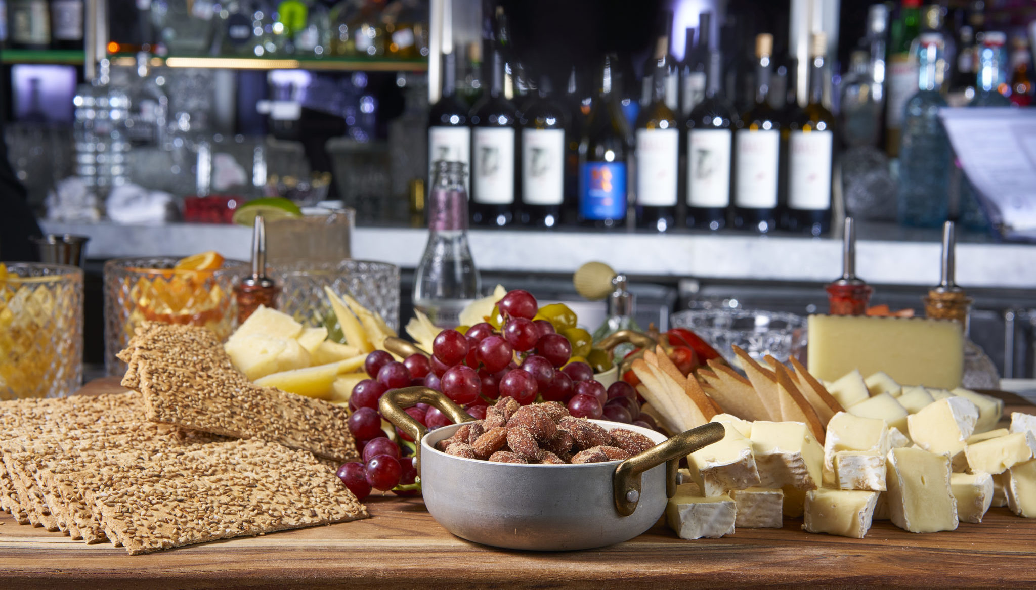 Charcuterie board with crackers, grapes, cheese, and almonds.